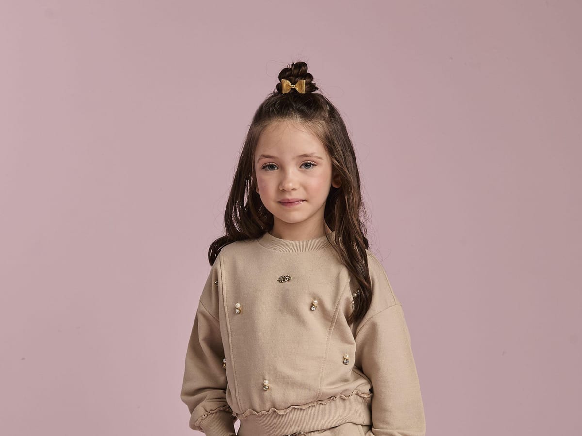 Menina com vestido fluido e casaqueto jeans — exemplo de roupa infantil feminina versátil